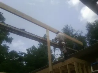 Carpenter setting a ridge beam over a new addition frame — Ice Dam Removal by Roofing Brothers in Prairie View