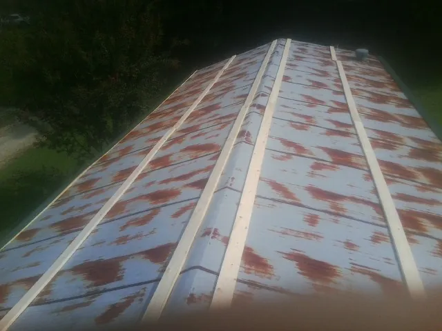 Rusted metal roof panels with new wood purlins before replacement — Storm Damage Roof Repair in Prairie View by Roofing Brothers