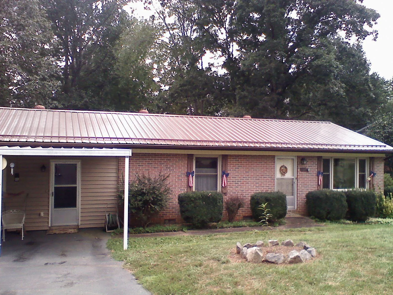 Bronze metal roof and carport on a brick ranch home — Roof Repair work by our crew in Prairie View