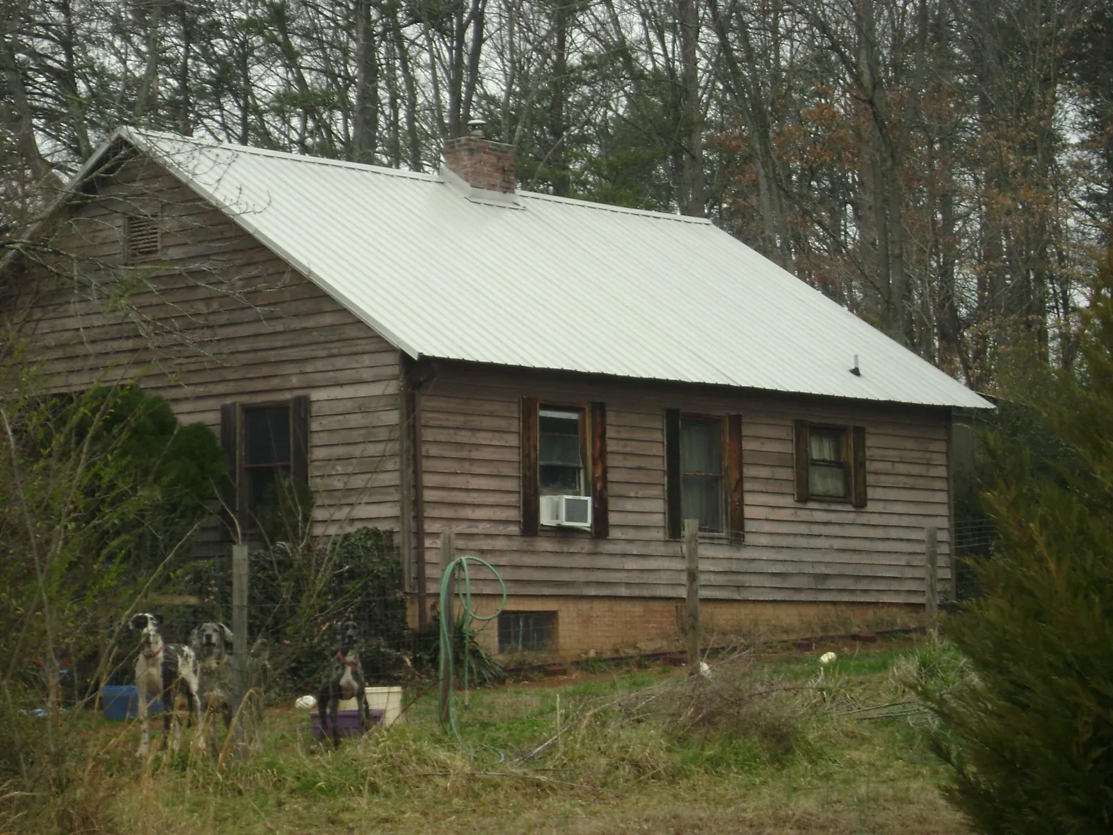 White metal roof on an old wood sided farmhouse, from a Metal Roof Installation job in Prairie View